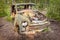 Old rusted scrap car in a forest