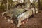 Old rusted scrap car in a forest