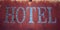 Old rusted sign. \'HOTEL\' word. Aged photo. Close up.