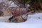 Old rusted wheelbarrow in the snow and left behind