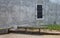 An old rustic alley wall with one solitary barred window.