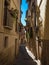 Old rustic mediterranean traditional house facade wall narrow alley lane road street in Toledo Castilla La Mancha Spain