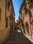 Old rustic mediterranean traditional house facade wall narrow alley lane road street in Toledo Castilla La Mancha Spain