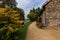 An old rustic stone barn for storing grain and grain near an earthen path