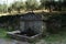 Old rustic water fountain by the rural road, olive grove