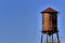 Old, rustic water tower with blue sky background