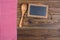 Old rustic wooden background with a wooden cooking spoon and an old slate blackboard