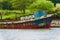 Old rusting boat sits tied at dock