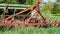 Old, rusty and abandoned agricultural machinery among the undergrowth on a fruit farm