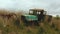 Old rusty abandoned car in the field.