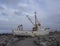 Old rusty abandoned fishing boat, ship wreck standing on rock, s