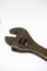 Old, rusty adjustable wrench on a white background close-up