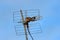 An old rusty analog television antenna tied to a bamboo stick