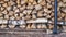 An old rusty axe stands against the woodpile