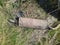 old and rusty battered muffler from a car in the woods