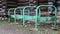 Old rusty bicycle parking made of metal bent pipes painted green, sticking out of the ground without a bicycle in the countryside