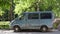 An old rusty blue minibus parked in the courtyard