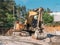 Old rusty broken hydraulic excavator machine in sand quarry, forgotten industrial machinery