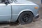 An old rusty car with a punctured front wheel