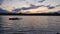 Old, rusty catamaran frame forgotten on the pond. Scenery landscape, peaceful evening sky with colorful clouds and small waves on