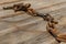 Old rusty chain lies on a wooden table selective focus