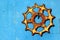 Old rusty cogwheel hanging on blue metal wall background