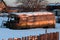 Old rusty and collapsed bus shrouded in snow.