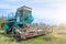 Old rusty combine harvester equipment in an abandoned collective farm.