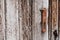 Old rusty deadbolt handle on a weathered wooden door