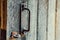 Old rusty deadbolt handle on a weathered wooden door