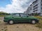 Old, rusty, dented scrap green car Nissan Almera four doors sedan parked