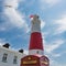 Old Rusty English Telephone Booth in front of Portland Bill Lighthouse