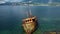 old rusty fishing boat shipwreck on shore of Kotor Bay