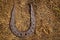 Old, rusty horseshoe on the ground. Concept of good luck