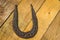 Old, rusty horseshoe on the wooden Background. Concept of good luck