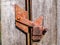 Old rusty iron bolt of a wooden gate lock