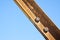 Old rusty iron structure with bolted metal profiles against a blue sky