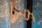 Old rusty key and keyhole on a blue wooden door