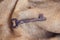 Old rusty key for treasure secret on vintage jute fabric