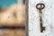 Old rusty key on the wooden door framea reflection of a blue sea on a dirty glass