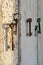 Old rusty keys illuminated by sunlight on the shabby wooden door frame with broken white paint