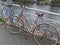 Old rusty lady`s bicycle, parked at a bridge railing and then forgotten