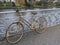 Old rusty lady`s bicycle, parked at a bridge railing and then forgotten