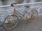 Old rusty lady`s bicycle, parked at a bridge railing and then forgotten