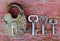 Old rusty lock with three different keys on wooden surface