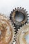 Old rusty mechanical gears on scratched metal background,