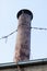 Old rusty metal chimney held with wire