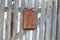 Old rusty metal mailbox on a wooden fence