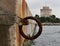 An old rusty metal mooring ring on the mooring wall on a sunny summer day. A device for holding sea vessels in port. heavily
