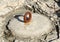 Old, rusty metal mooring ring on the stone block in the midday sunlight with silhouette of the stone